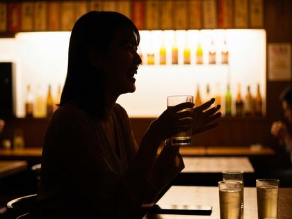 居酒屋で楽しそうに談笑する20代女性のシルエット