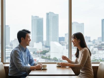 カフェで楽しそうに話す男女、横浜の街並みが見える窓辺