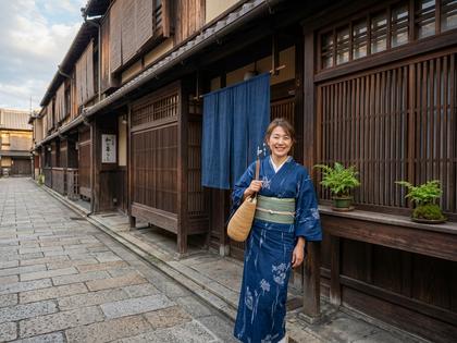 京都の町家を背景に自然な笑顔でポーズをとる女性
