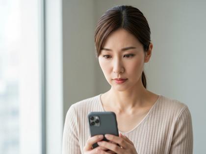 スマホを見て注意深い表情の女性