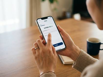女性がスマートフォンで会員情報を入力する画面を操作。