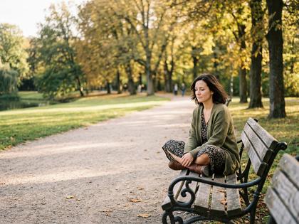 公園のベンチで一人考え事をする女性