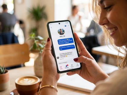 スマホでメッセージのやり取りを見て笑顔になる女性