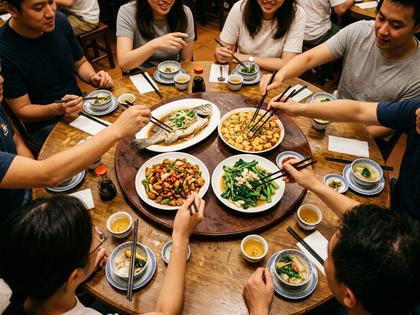 中華料理の大皿を囲んで取り分けあう友人グループのテーブル写真