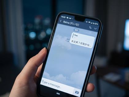 スマートフォンの画面に既読の文字だけが表示され、返信が来ていないLINEのトーク画面を見つめる20代女性