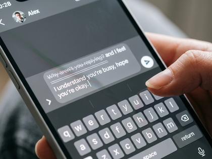 送信ボタンを押す直前で指を止めてためらっている女性の手元のクローズアップ