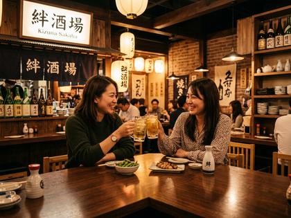 カウンター席で女性ふたりがグラスを合わせる、温かみのある居酒屋の店内
