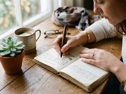 一人でノートに気持ちを書き出している女性の手元、800px×600px