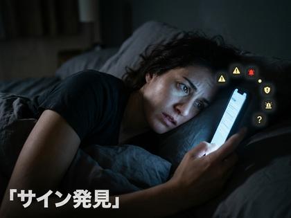 夜のベッドでスマホの通知を見つめ、表情が曇っている女性の横顔