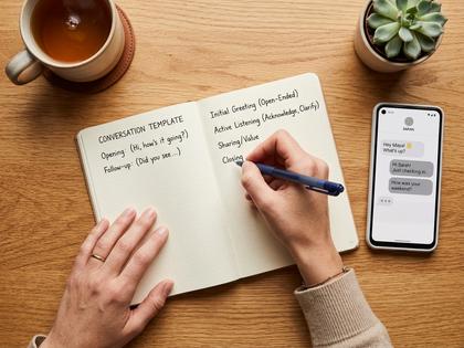 ノートに会話のテンプレートを書き出している女性の手元、ペンとスマホ