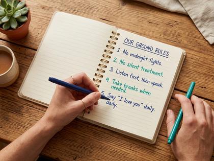 ノートに二人でルールを書き出しているカップルのイメージ、明るいリビング